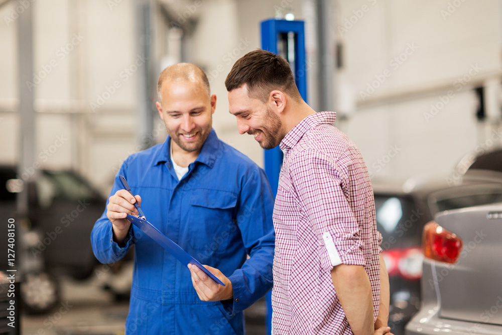 Fototapeta premium auto mechanic with clipboard and man at car shop