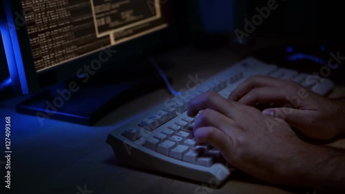 close up of a hacker in front of a computer display typing on a keyboard with tapping sound
