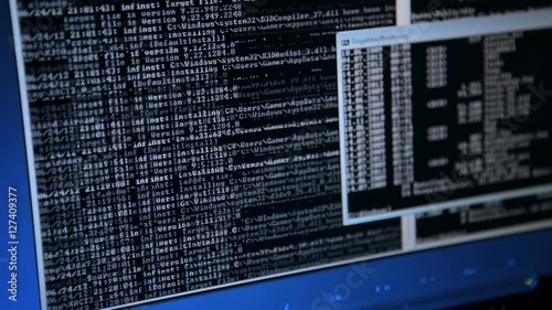 close up pan shot of a computer display doing network computing in the background