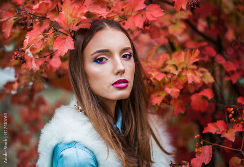 beautiful and fashionable girl in the autumn viburnum
