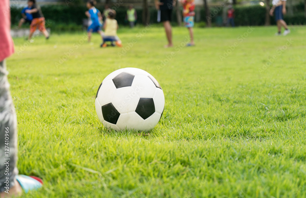Close up of an soccer ball on the field, players in the backgrou Close up of an soccer ball on the field, players in the backgrou