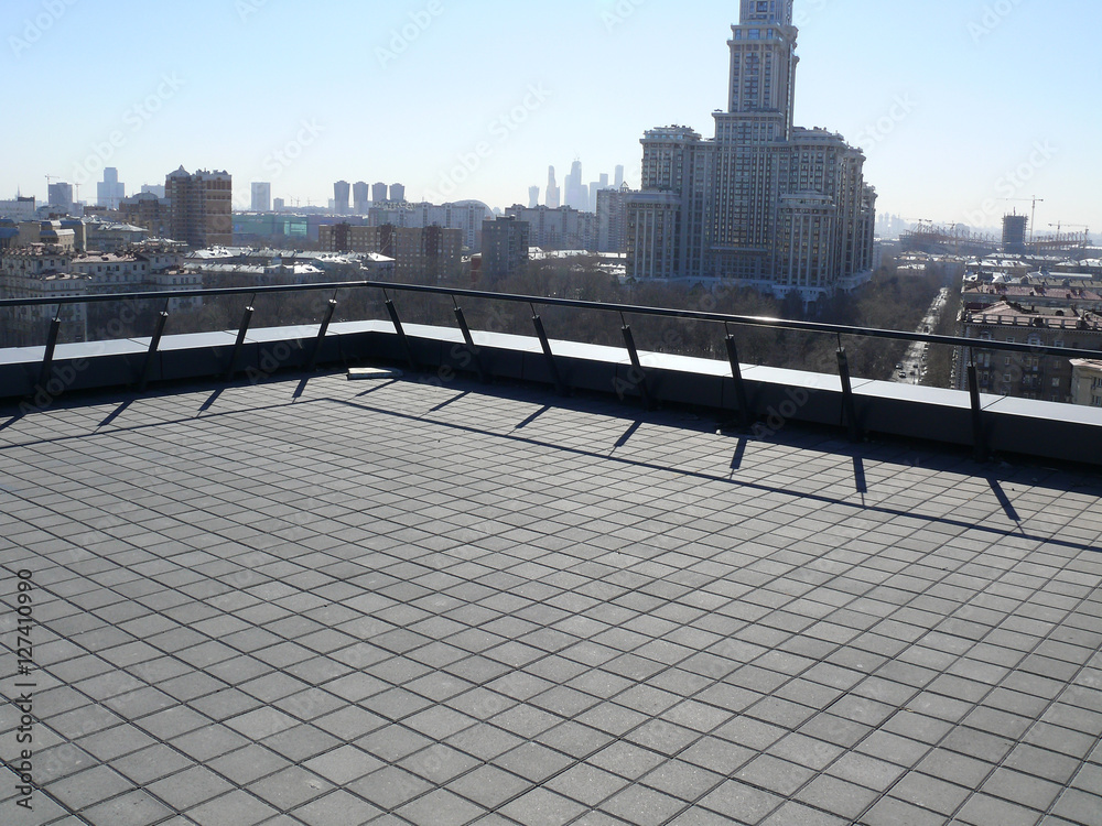 a rooftop balcony with a cityscape background