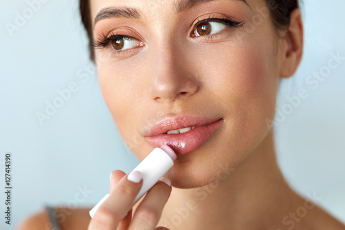 Tableau sur toile Beautiful Woman With Beauty Face Applies Balm On Lips. Skin Care