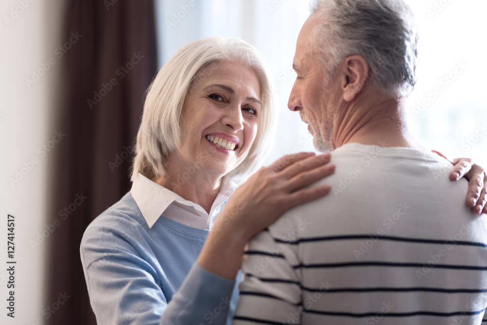 Delighted aged couple hugging each other at home Delighted aged couple hugging each other at home