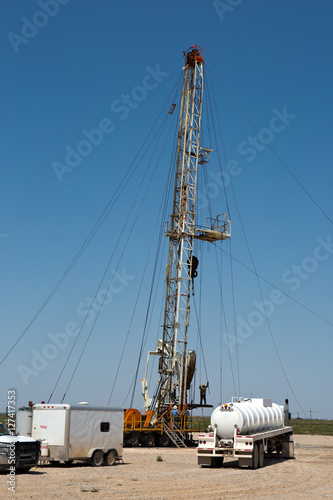 Oil drilling crew, called roughnecks, work a derrick rig in the oil well fields.