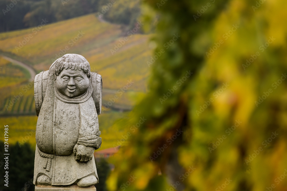 Andlau, Alsace village, vineyard, statue of monk carrying wine barrel