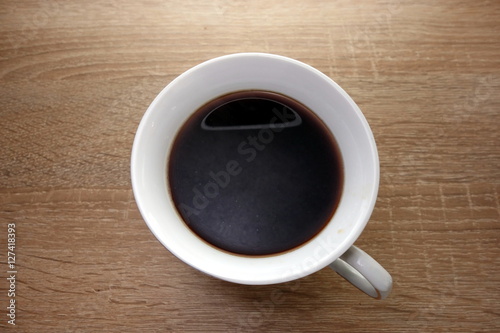 Morning coffee cup on wooden background, closeup view from above 