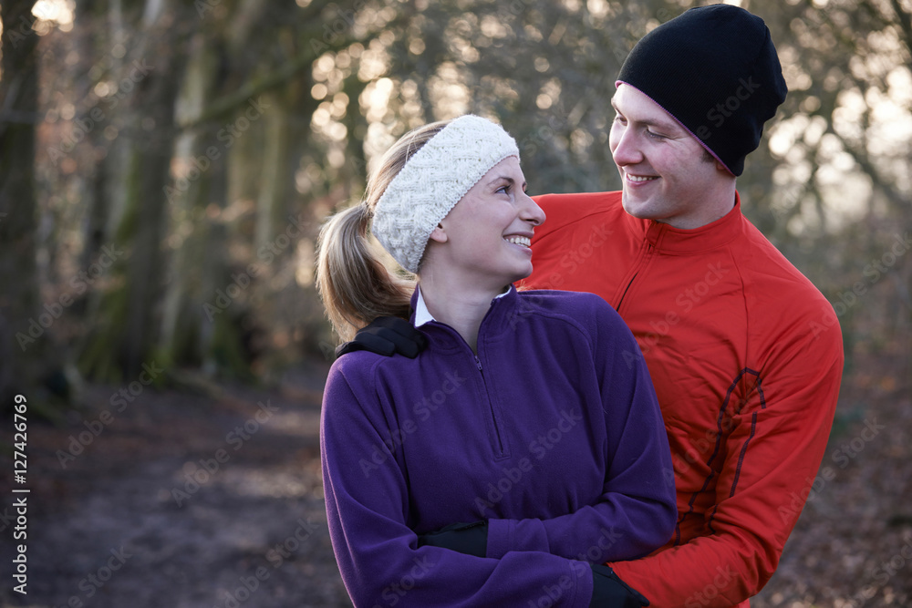 Fototapeta premium Young Couple On Winter Run Through Woodland