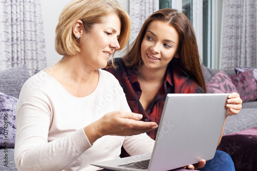 Teenage Daughter Showing Mother How To Use Laptop Computer © highwaystarz