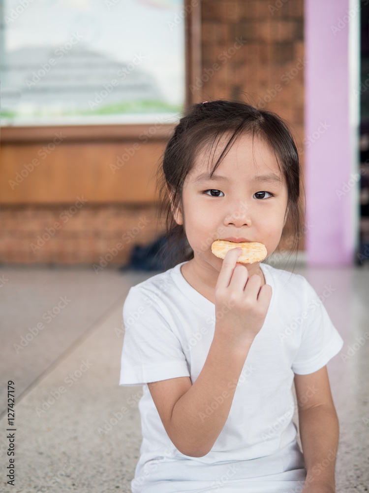 little asian  child girl eating a cookie