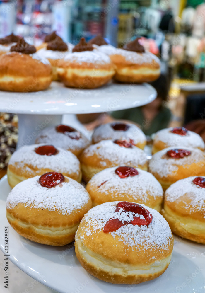 Close up of fresh donuts on bakery display for Hanuka celebration. Selective focus.