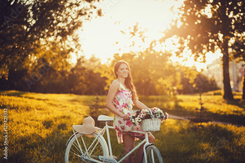 young woman with a bike in the park