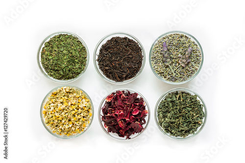 Six bowls with different tea leaves isolated on white background.