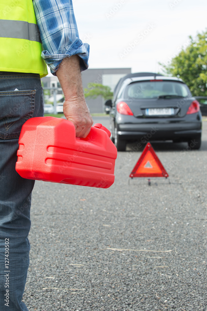 Fototapeta premium senior aged man holding gas can to refill his car