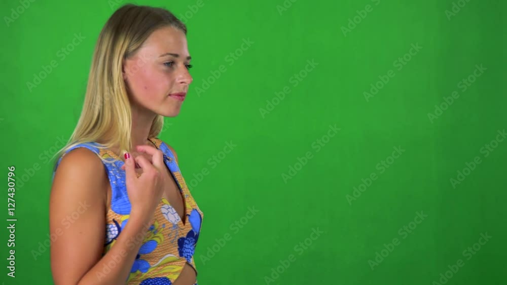 young pretty blond woman walks and thinks about something - green screen 