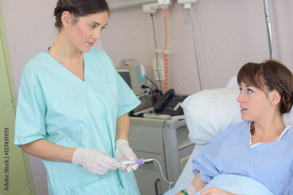 Nurse administering intravenous drug to patient Nurse administering intravenous drug to patient