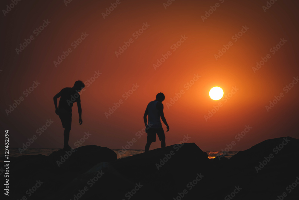 two guys at sunset at sea