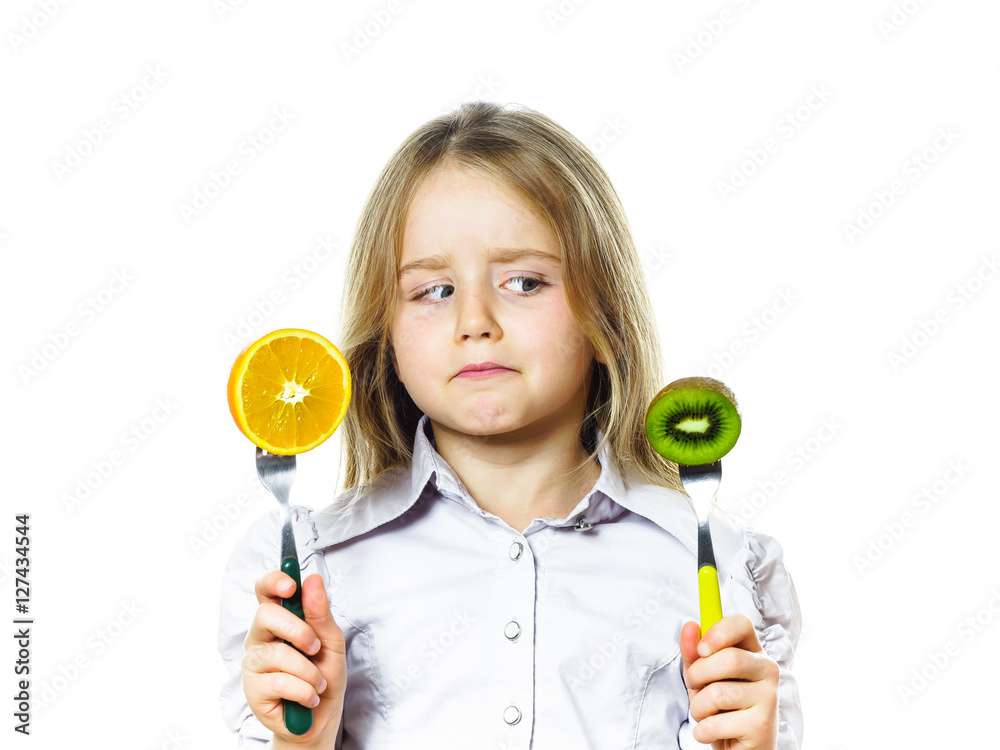 Funny little girl selecting between kiwi and orange Funny little girl selecting between kiwi and orange