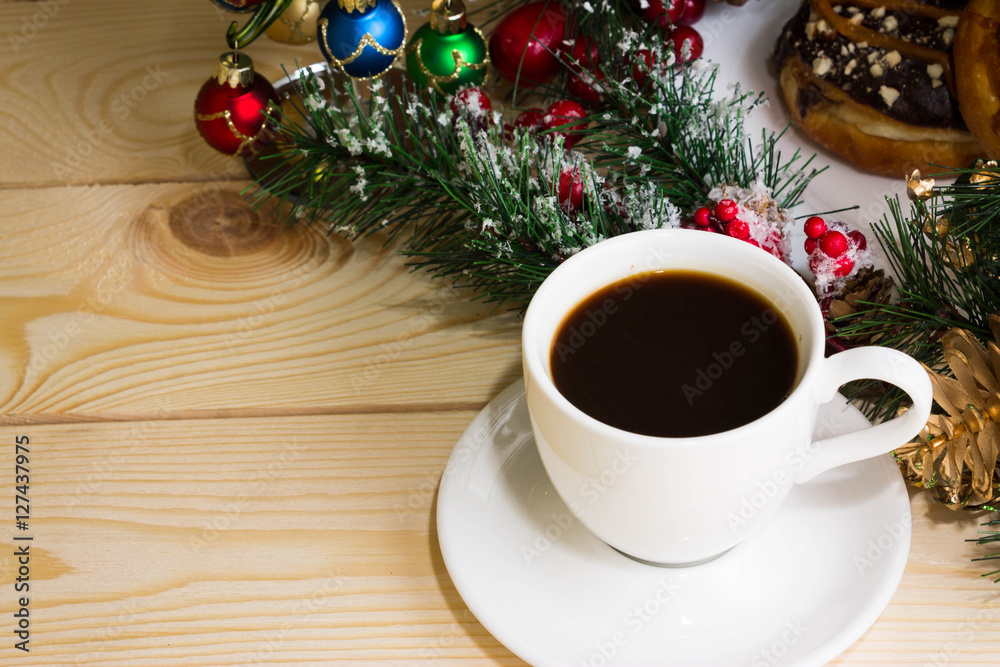 A cup of coffee with fir branches and Christmas decorations. Christmas background. A cup of coffee with fir branches and Christmas decorations. Christmas background.