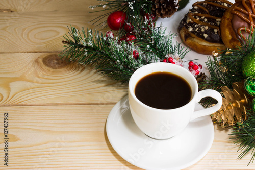 A cup of coffee with fir branches and Christmas decorations. Christmas background.