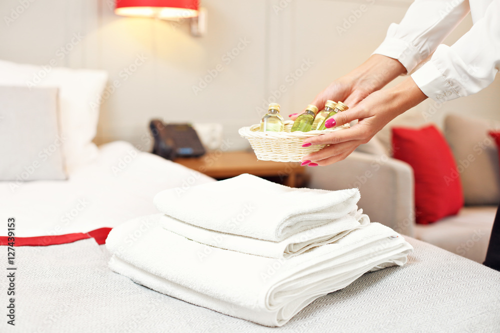 Maid preparing cosmetics set in hotel room