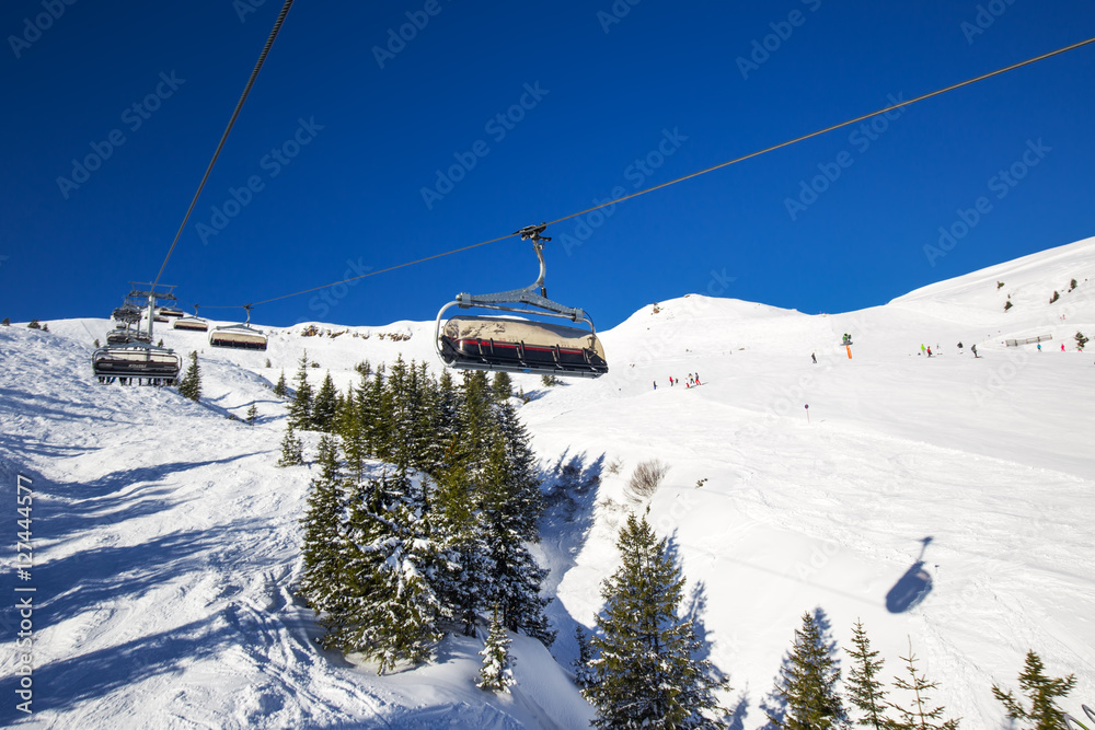 Skiers on chair lift in Kitzbühel ski resort, Tyrolian Alps, Austria Skiers on chair lift in Kitzbühel ski resort, Tyrolian Alps, Austria