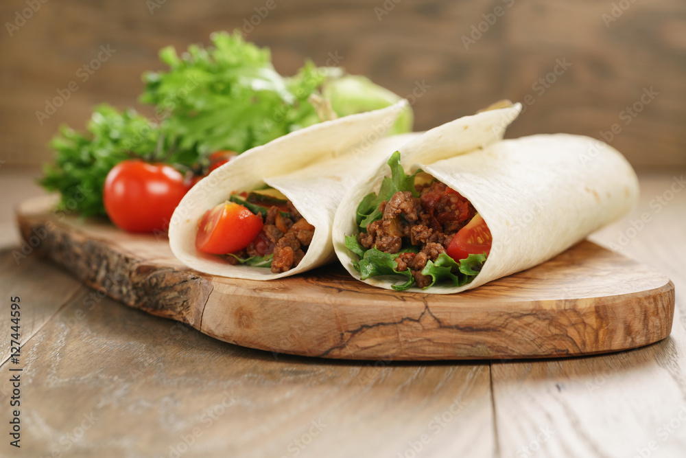 homemade tortilla with beef, frillice and vegetables on wooden board homemade tortilla with beef, frillice and vegetables on wooden board