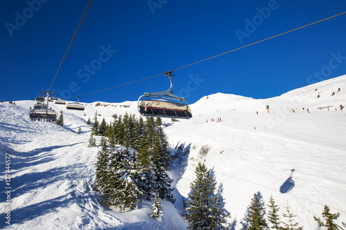Skiers on chair lift in Kitzbühel ski resort, Tyrolian Alps, Austria