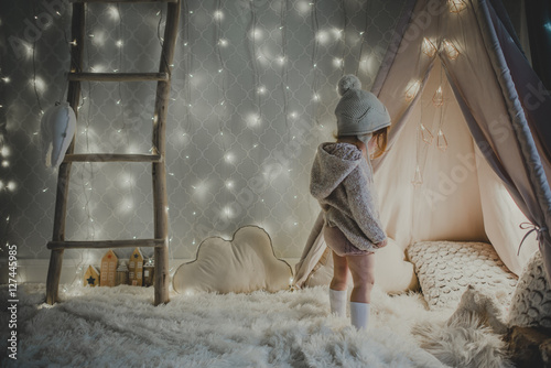 Little girl looking mesmerized by a wondrous tent
