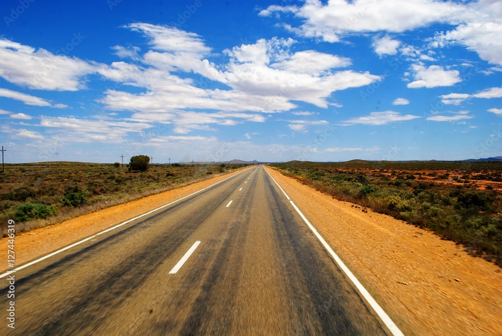 straight road through the australian desert under blue sky