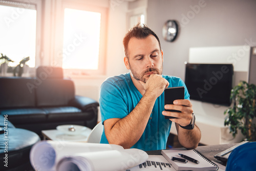 Man using smart phone and contemplating