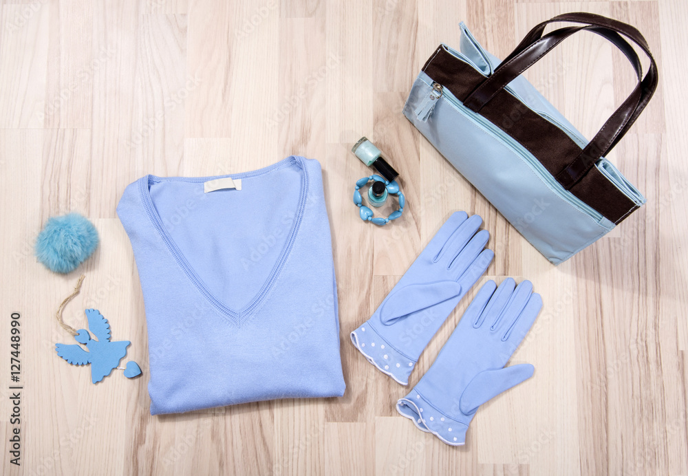 Winter sweater and accessories arranged on the floor.Woman blue and brown accessories,necklace and gloves lied down. Winter sweater and accessories arranged on the floor.Woman blue and brown accessories,necklace and gloves lied down.