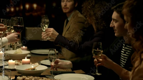 Group of people making a toast at a restaurant.
