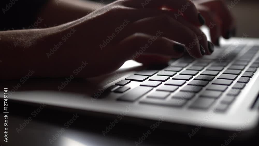 Young woman typing on a laptop keyboard
