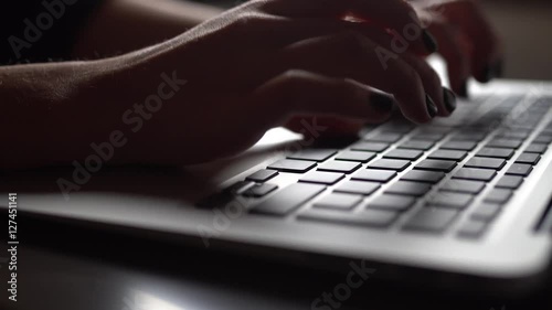 Young woman typing on a laptop keyboard photo