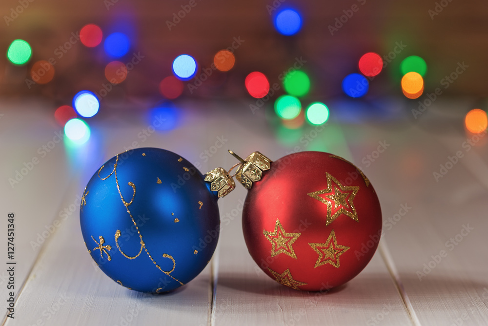Fototapeta premium Decorative Christmas balls on wooden board with colorful bokeh background.