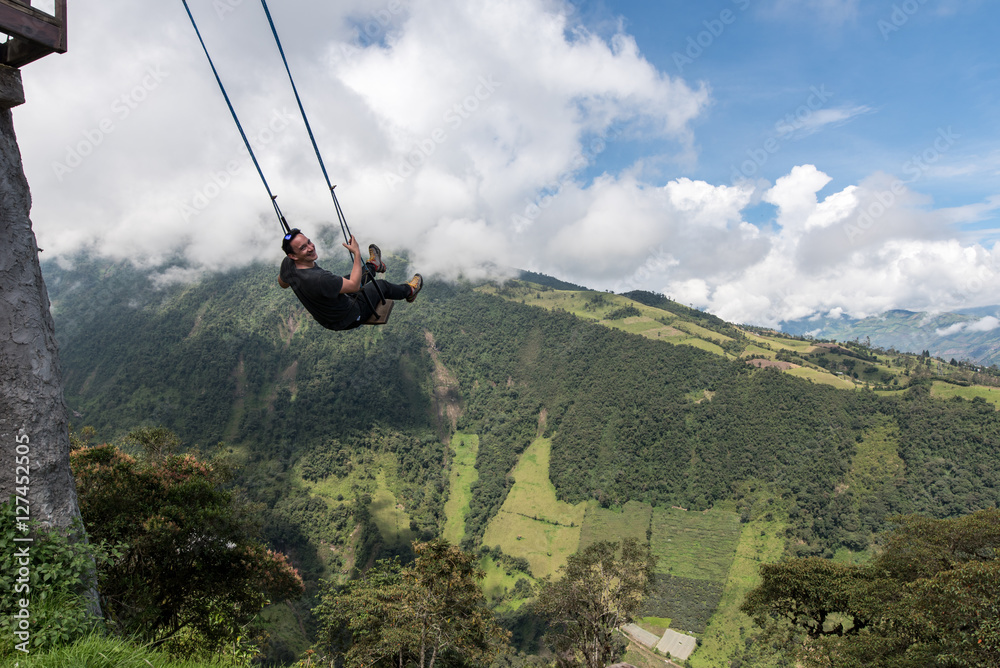 Man swings at Casa del Arbol, swing and treehouse vis-a-vis volcan Tungurahua Man swings at Casa del Arbol, swing and treehouse vis-a-vis volcan Tungurahua