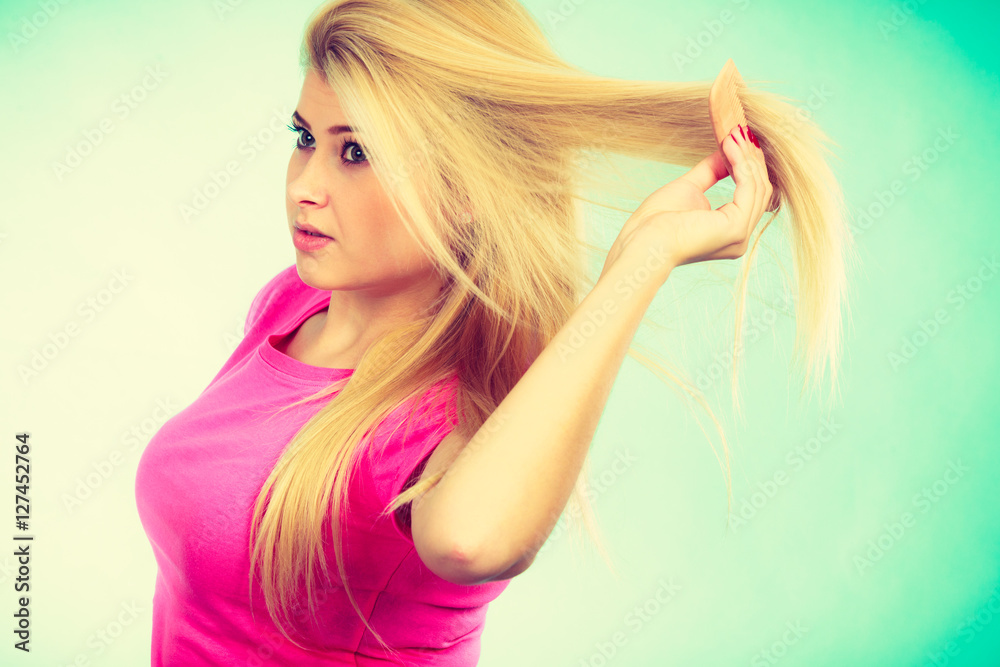 Fototapeta premium Blonde woman brushing her long hair