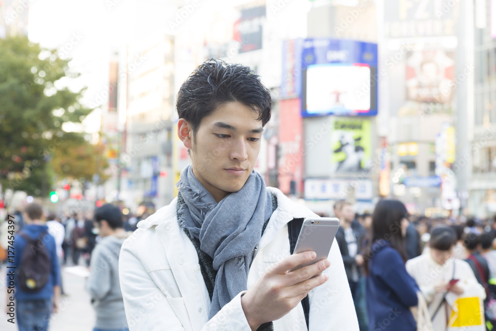男性 渋谷駅前 渋谷スクランブル交差点前でスマホを操作 屋外 男性 渋谷駅前 渋谷スクランブル交差点前でスマホを操作 屋外