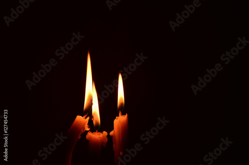 light candle burning brightly in the black background