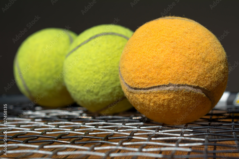 La pelota de tenis anaranjada está primera.