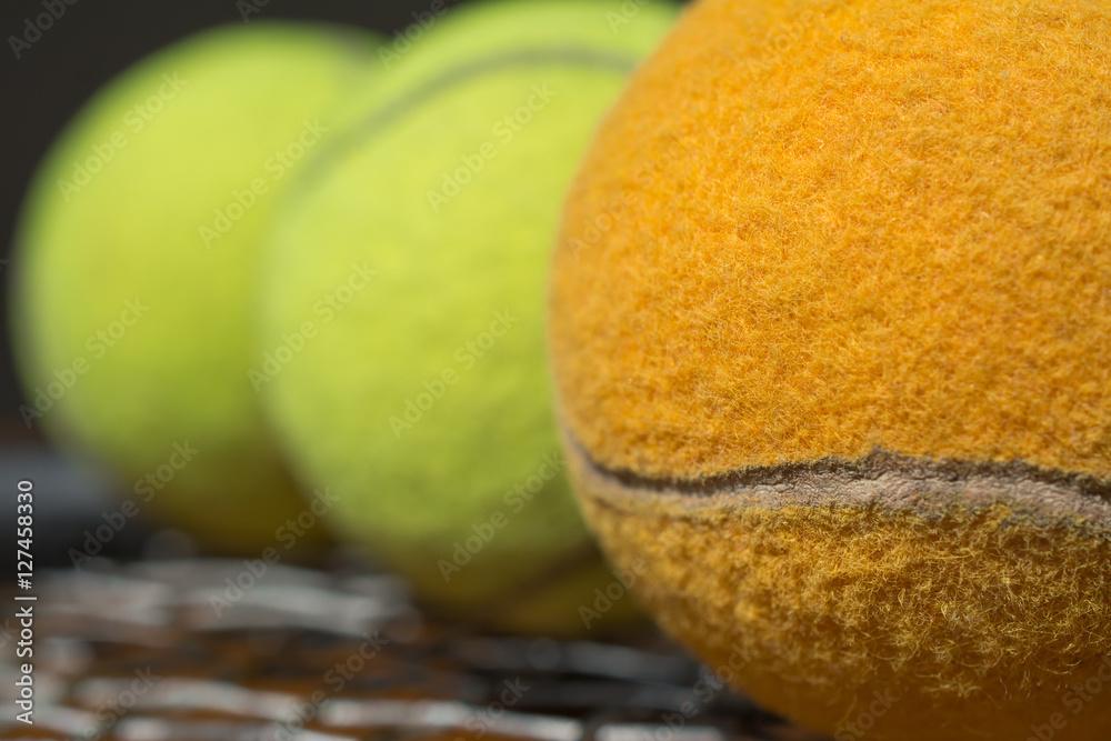 La pelota de tenis anaranjada está adelante.