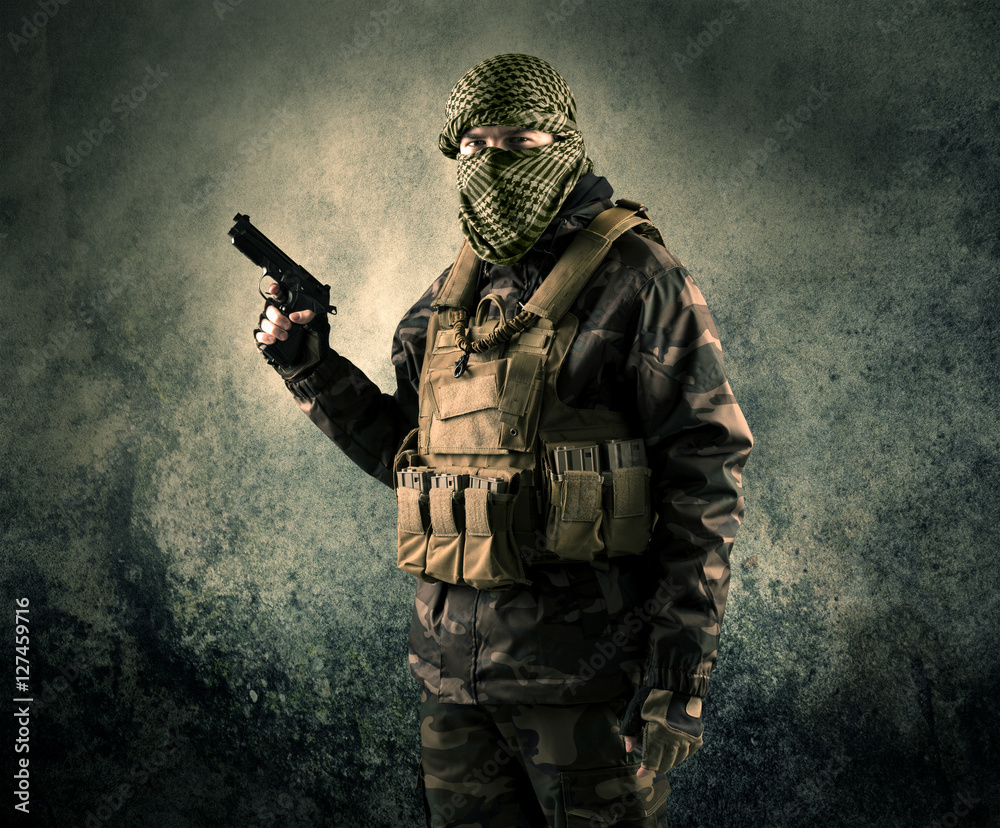 Portrait of a heavily armed masked soldier with grungy backgroun Portrait of a heavily armed masked soldier with grungy backgroun