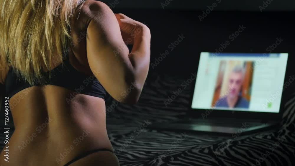 woman gets undressed in front of webcam while a man is watching