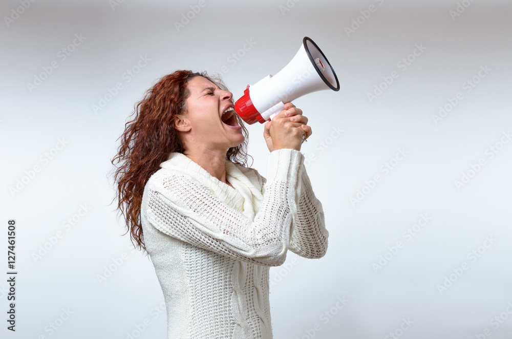 Young woman shouting into a megaphone Young woman shouting into a megaphone