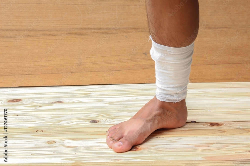 Gauze bandage the treating case with ankle Injured on wooden Gauze bandage the treating case with ankle Injured on wooden