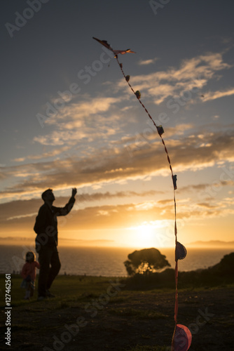 Father and daughter fly kite at sunset © The Motion Bar