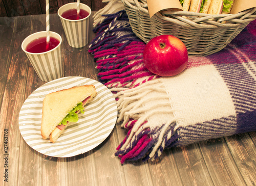 A picnic with lemonade,picnic basket, sandwiches, bananas, apples, plaid