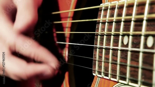 Closeup shot of a musician strumming the guitar strings