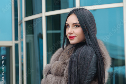 Beautiful girl with a smile in fur waistcoat